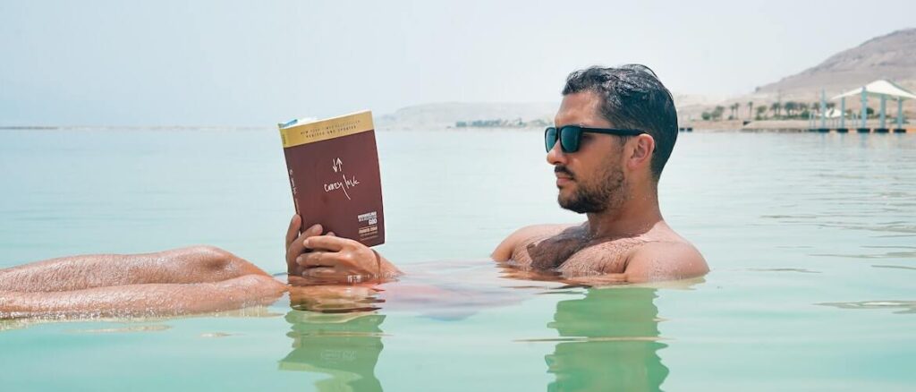voor deze man is lezen heel belangrijk want hij leest zelfs in het water