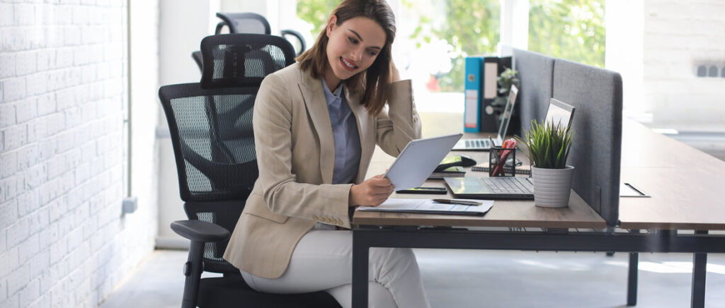 Op deze foto zit een vrouw in een comfortabele ergonomische bureaustoel